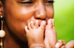 Kissing her newborn's feet