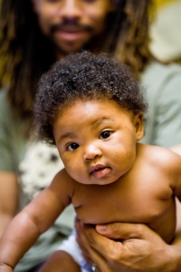 Newborn and father with dreadlocks